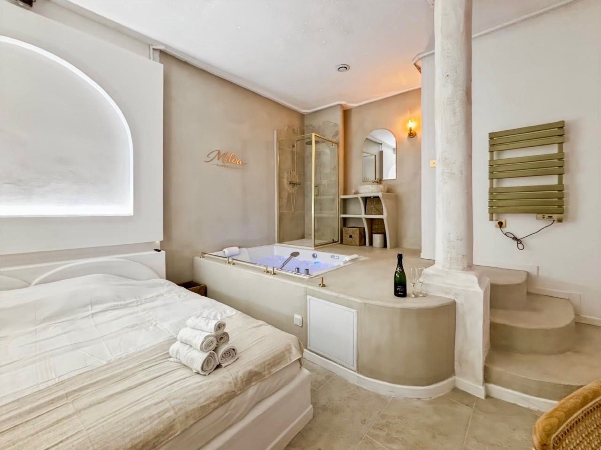 Lit et jacuzzi vus depuis l'entrée de la Balnéo Room