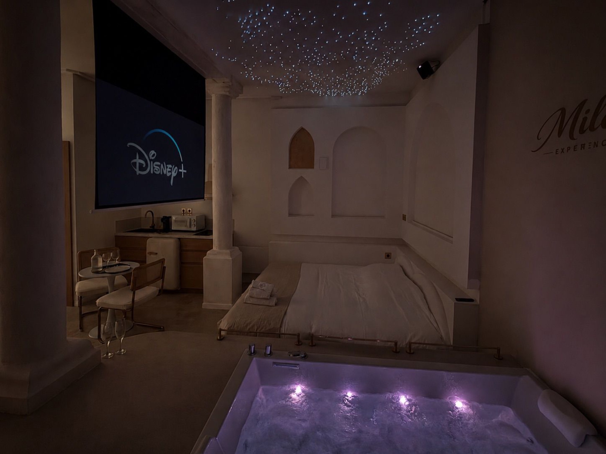 Ambiance nocturne : plafond étoilé, écran et jacuzzi violet