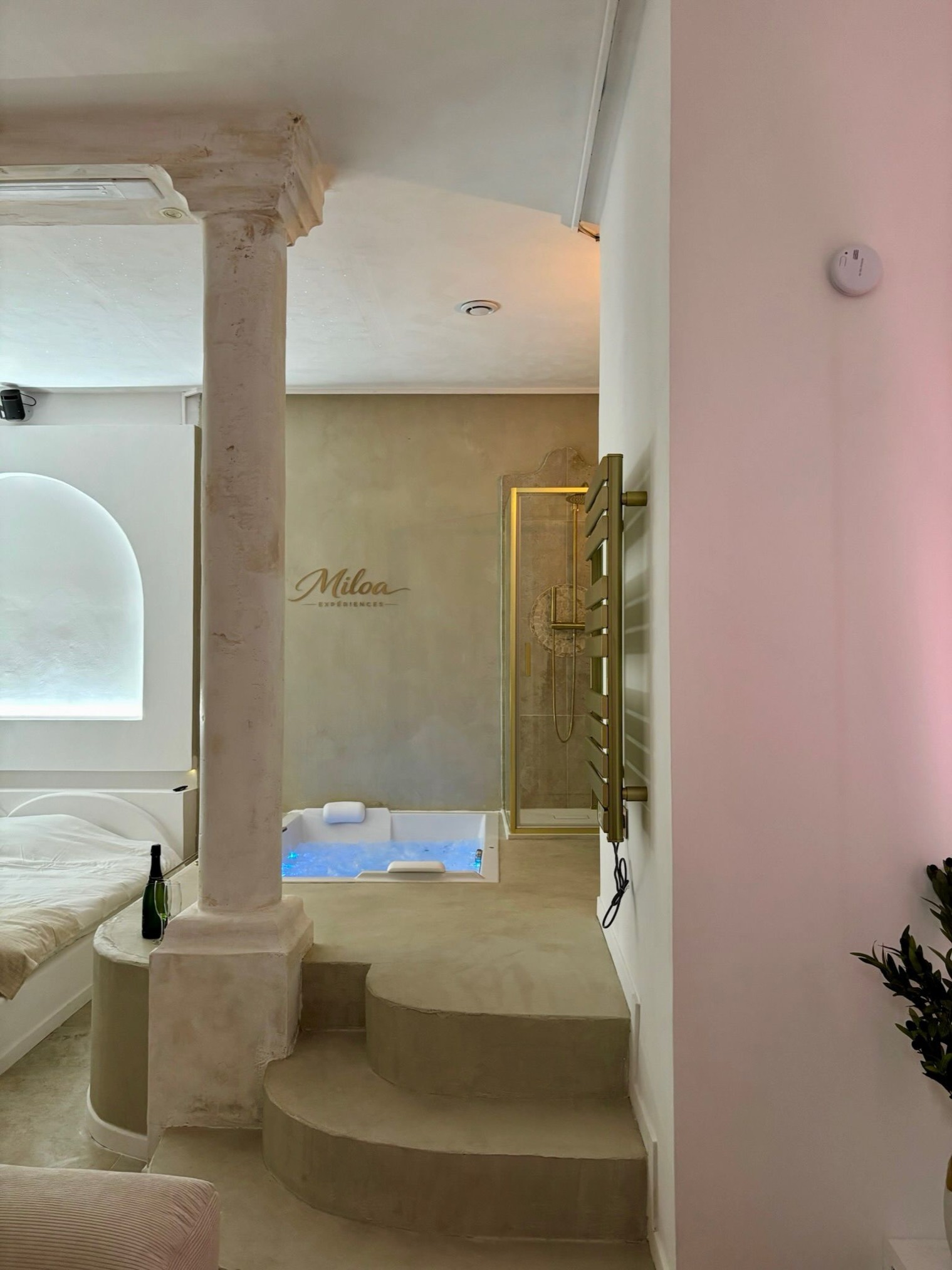 Jacuzzi et escalier menant au salon, ambiance rosée