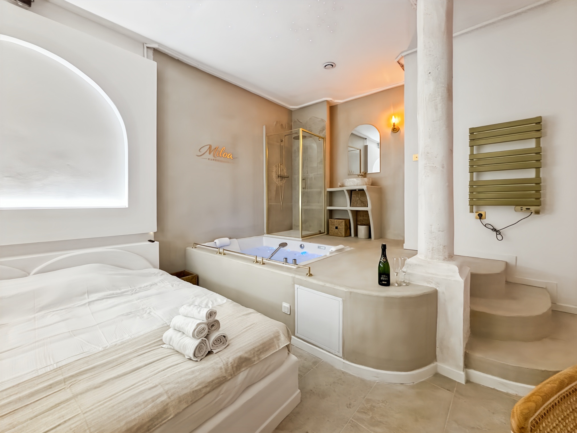 Lit face au jacuzzi et à la colonnade blanche de la Balnéo Room, en fin de journée