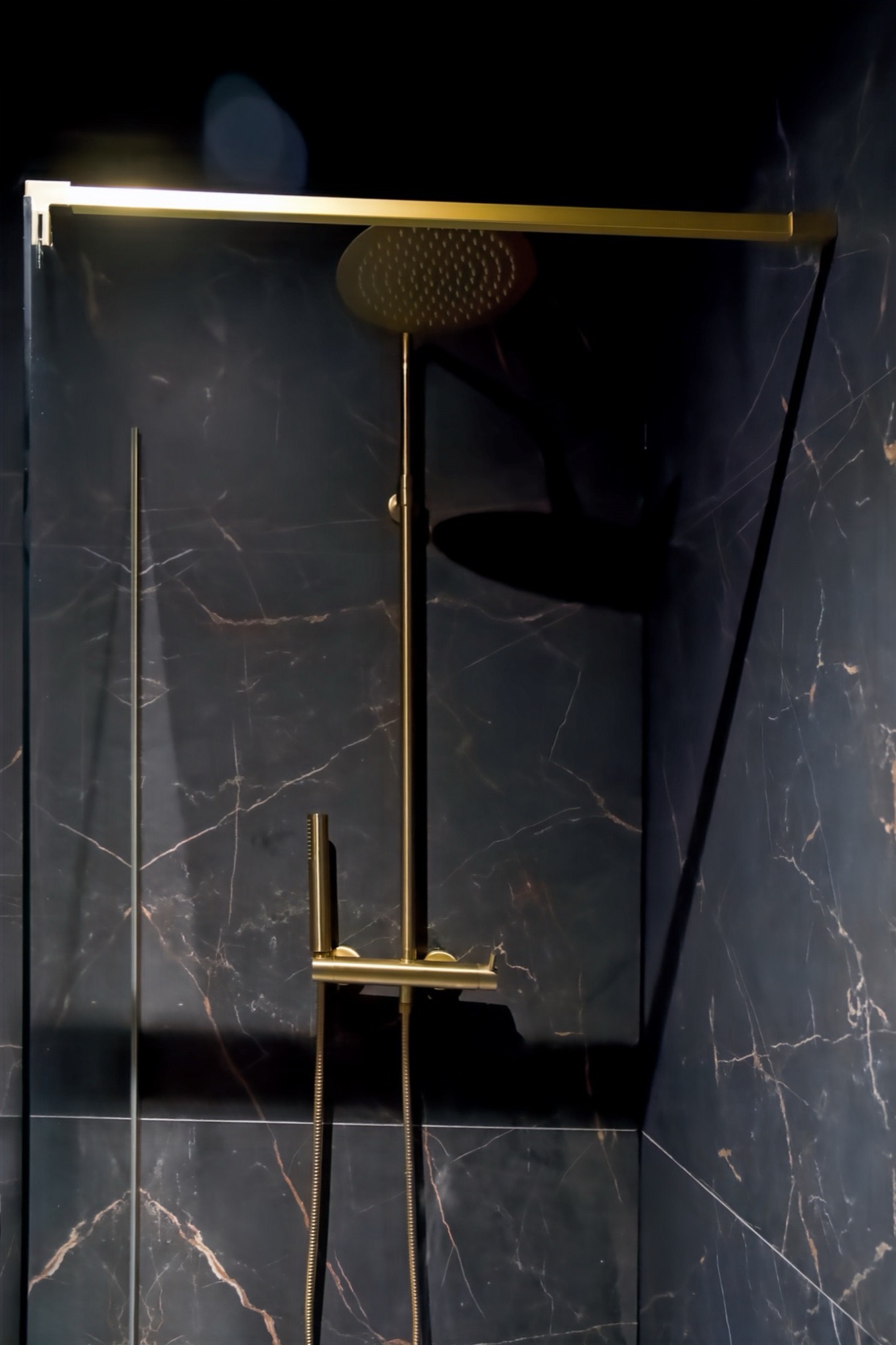 Douche à l'italienne dorée et marbre noir de la Ciné Room